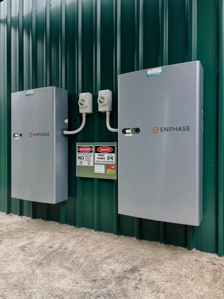 Two slim Enphase IQ Battery 5P units mounted vertically on a garage wall