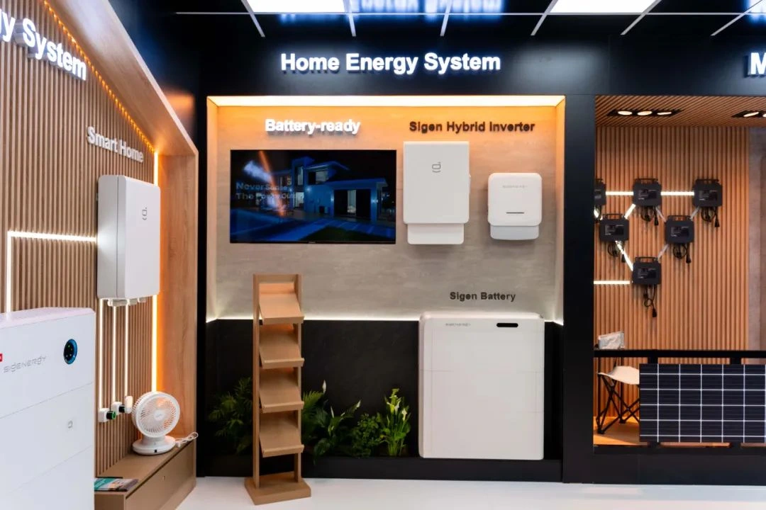 Sigenergy home energy system hardware (booth display). Sigenergy home energy system display showing hybrid inverter and battery units in a showroom booth.